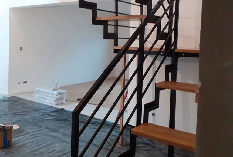drewniane schody z czarną balustradą